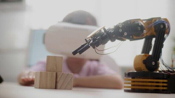 女孩在VR眼镜上控制机器人手臂在高中上机器人课