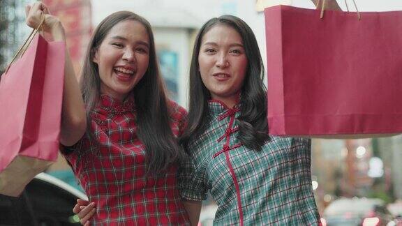 亚洲女游客在曼谷与煎蛋卷自拍这对夫妇喜欢在交通繁忙的姚瓦拉特路上吃路边小吃美丽的亚洲妇女穿着传统的红色旗袍在中国新年