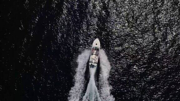 空中俯瞰一艘白色快艇在波光粼粼的海洋上巡航