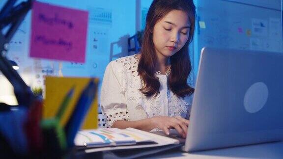 自由亚洲女性使用笔记本电脑努力工作在新的正常的家庭办公室