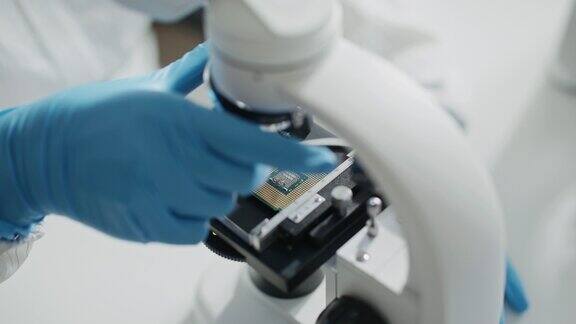 工程师科学家穿着工作服和手套的特写镜头用显微镜检查主板微处理器组件