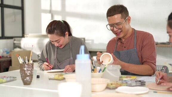 4K群亚洲人朋友喜欢在陶艺坊一起画自制陶器