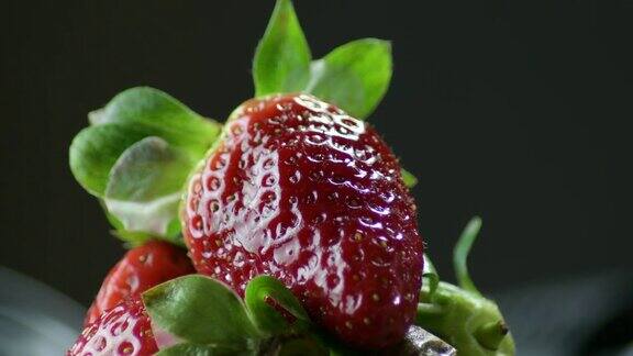 草莓果实在草莓山的黑色背景中旋转