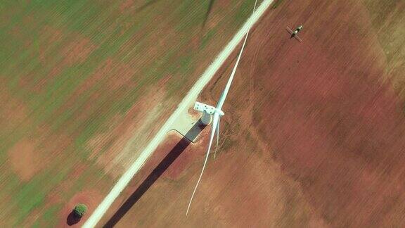 西班牙绿色农田上的风力涡轮机和作物喷洒拖拉机鸟瞰图
