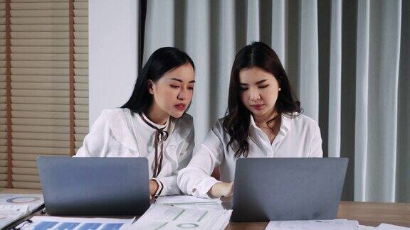 两个商务女性坐在办公桌前讨论项目细节不同的女同事在办公室会面分享意见共同完成任务销售经理向公司客户提出商业报价