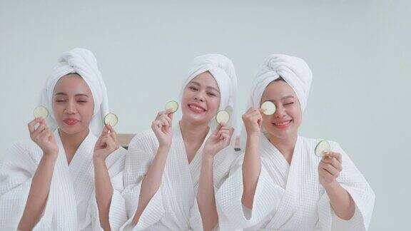 一群穿着浴袍的亚洲妇女用黄瓜护理眼睛