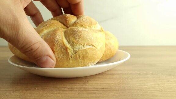 手把刚烤好的面包放在盘子里