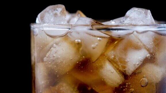 可口可乐在加冰的玻璃杯中冒泡
