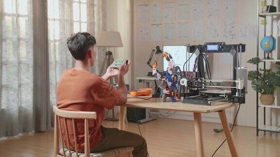 亚洲男孩的背影与3D打印握着和看着板而修复半机械人的手在家里