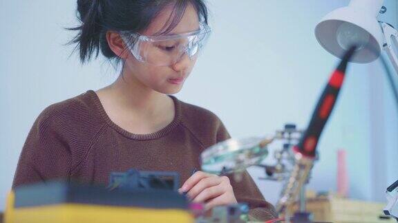 大学生在实验室里专心的维修电子元件