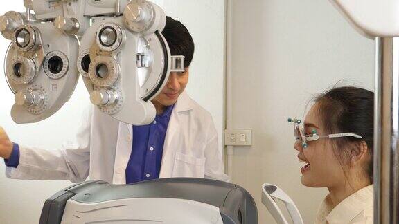 男性验光师使用试镜镜框检查女性视力而男性眼科医生试用试镜镜框并询问问题