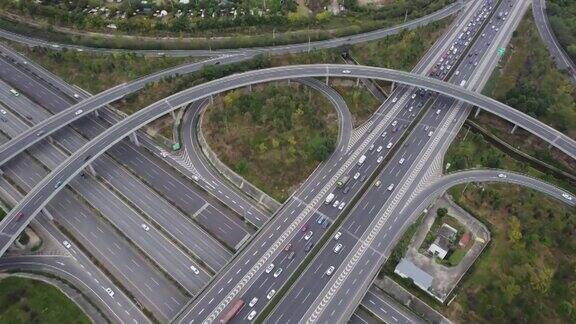 从无人机上俯视大城市多车道高速公路现代交通枢纽高速公路上交通拥挤高架弯道三叶草桥无车速限制