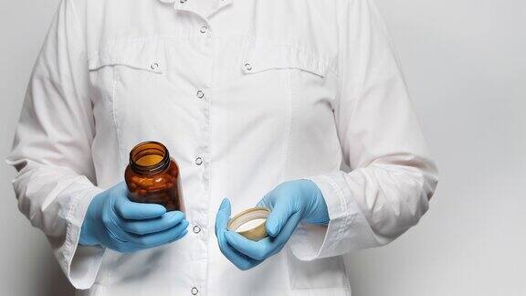 一位戴着蓝色手套的医生打开玻璃药瓶展示里面的药瓶4k特写慢镜头