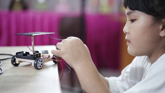 女孩在学校学习建造和修理机器人玩具STEM研究
