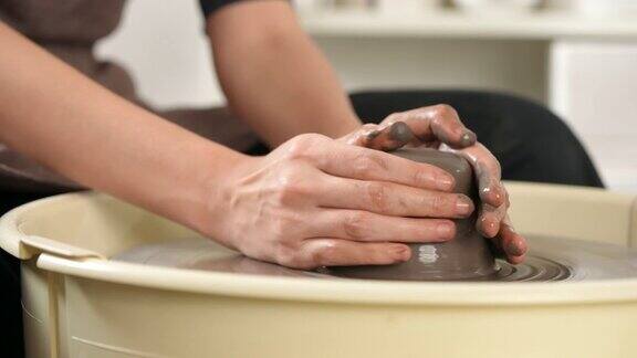 在陶瓷工作室里亚洲女雕刻家艺术家在陶轮上手工雕刻粘土