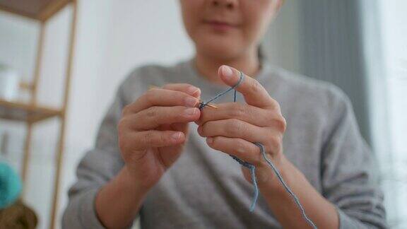 女性在家中客厅放松时的手编织钩针特写