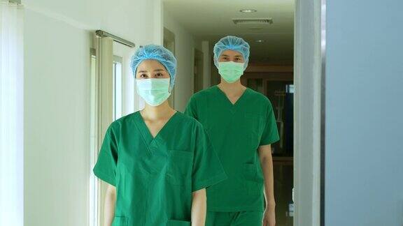 两名亚洲外科医生戴着医用口罩走向手术室进行整形手术医疗、美容和保健