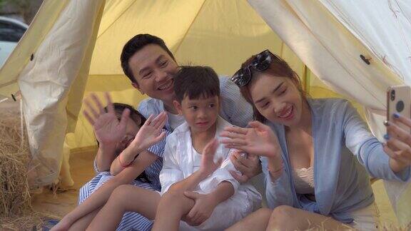 快乐的亚洲家庭在帐篷外自拍