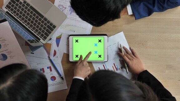 商业人士在绿色屏幕的平板电脑上分析财务数据