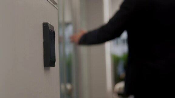 穿着西装的人用NFC的钥匙卡打开了办公楼的门