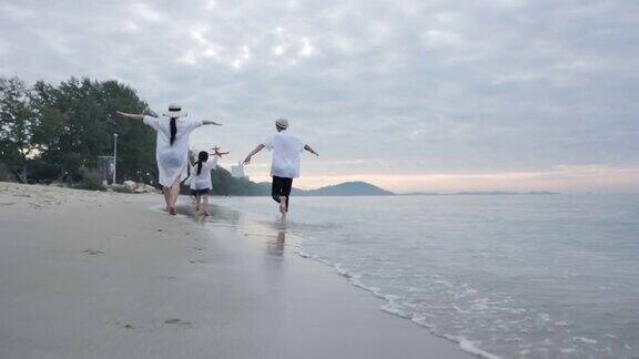 快乐的亚洲家庭一起在沙滩上跑步奔跑