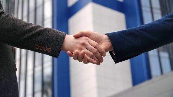 两个商人在市中心的户外互相握手友好地打招呼