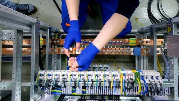 工厂电工工程师用螺丝刀安装电缆将电箱控制柜螺母拧紧至保险丝盒
