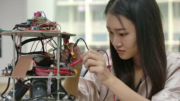 亚洲女性电子工程师与机器人一起工作在车间建造修理机器人有技术或创新观念的人