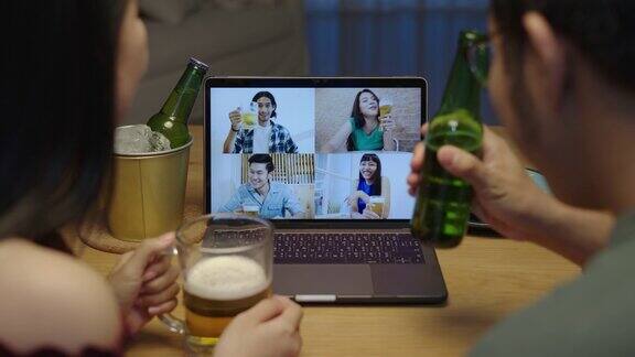 缩小:年轻快乐的亚洲夫妇享受放松的夜晚派对活动在线庆祝节日与朋友在家里碰杯啤酒和酒瓶敬酒通过视频电话喝