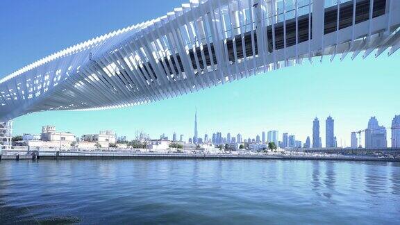 扭曲的桥有湖或河的建筑结构迪拜市中心阿拉伯联合酋长国或阿联酋城市金融区和商业区蓝天为背景
