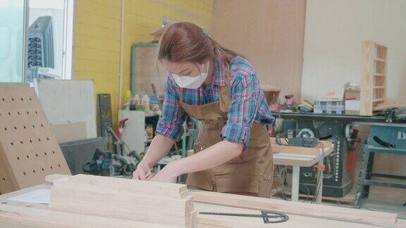 女木匠使用铅笔和尺子在木板上工作