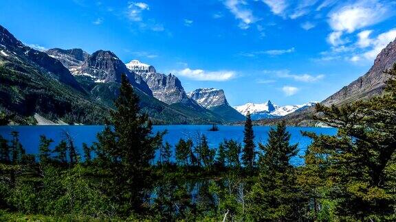 在圣玛丽湖的春天-在冰川国家公园美国蒙大拿州高云经过蓝色的圣玛丽湖和周围陡峭的山脉的全景的时间推移视频