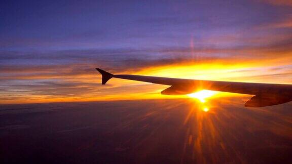 美丽的日出通过窗户在飞机机翼的实时时间
