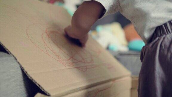 亚洲男婴正在纸板上画素描
