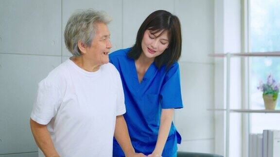 护士在医院照顾一位用助行器走路的老妇人