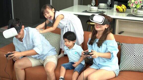 亚洲家庭两个孩子在看电视和玩游戏