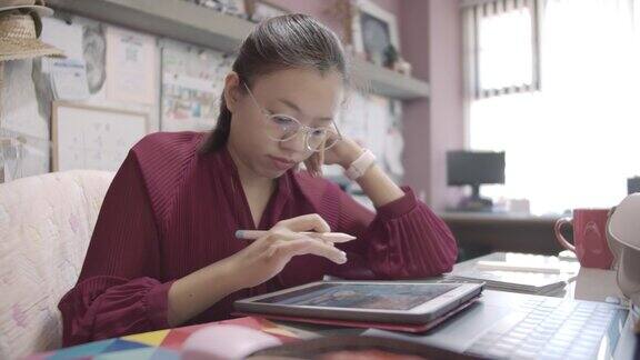 亚洲女商人在家庭办公室用平板电脑思考和工作