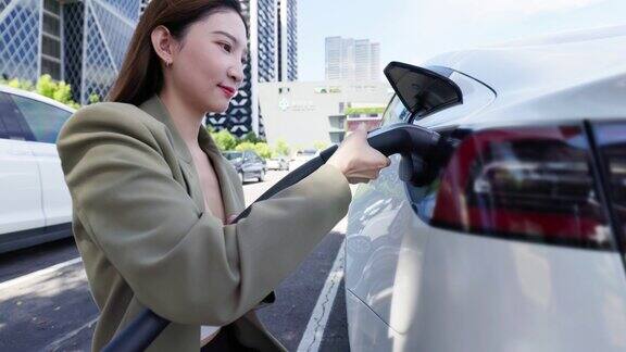 亚洲女性正在为电动汽车充电