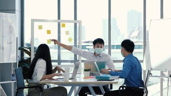 肖像组的亚洲在医疗标志在一个多样化的团队的创造性千禧同事在创业头脑风暴的策略三个商务人士在办公室开会时一起工作
