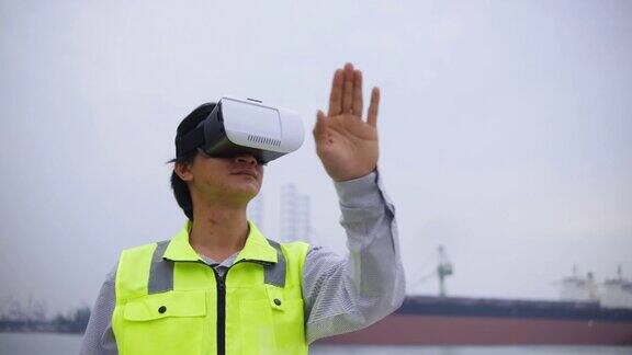 亚洲男性工程师戴着虚拟现实耳机在工业港