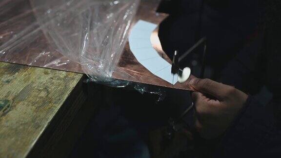 高角度视图的手亚洲男学生使用手锯在大学工作台