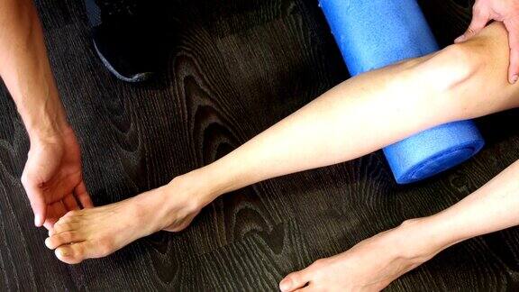 男性理疗师为女性病人进行腿部按摩