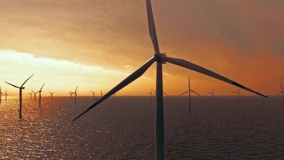 海上风力涡轮机的空中叶片在日落时旋转