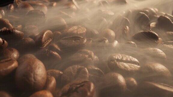 棕色烘焙咖啡豆与烟在黑暗的背景特写咖啡豆在烘焙过程中的滑块镜头烟来自新鲜的咖啡籽微距拍摄4K