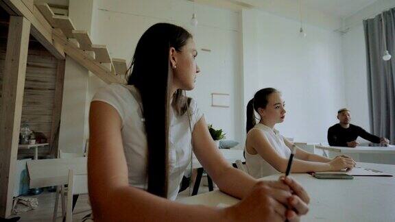 女性坐在商业教学培训中聆听导师