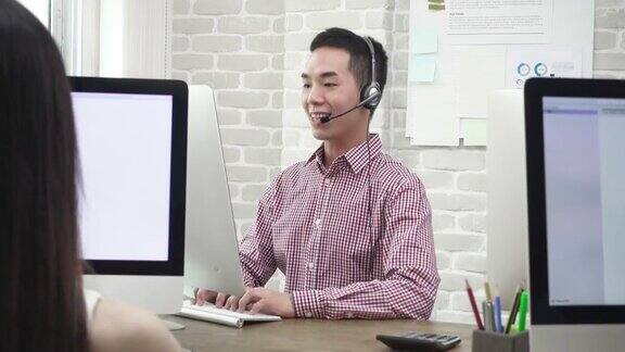 微笑的亚洲人电话销售客户服务代理人与客户交谈