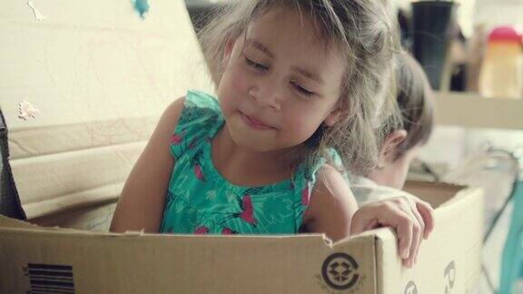 快乐的宝宝和她的妹妹在纸箱里玩