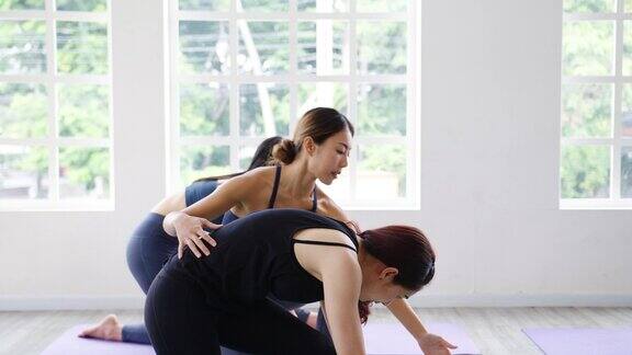 年轻的亚洲体育有吸引力的人练习瑜伽课与教练