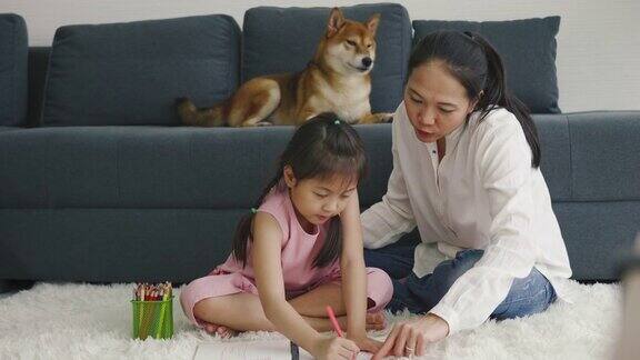 亚洲母亲和女儿和他们的狗一起画画家庭室内休息