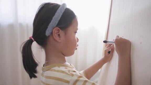 一个女孩在纸上用彩笔画画